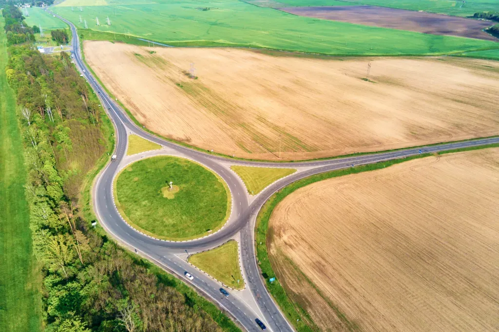 Luftaufnahme eines Kreisverkehrs inmitten von Feldern